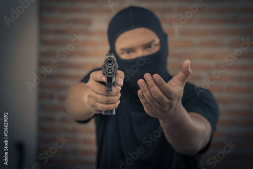 Portrait of man pointing gun indoors