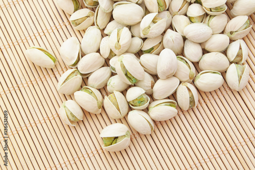 Pistachio nuts on bamboo background Pistachio nuts on bamboo background