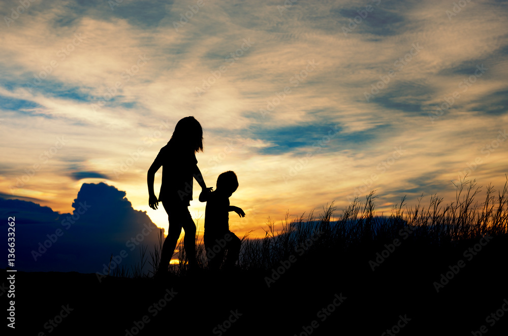 Silhouette, group of happy children playing on meadow, sunset, r