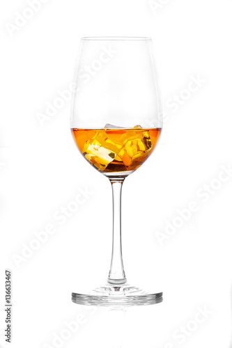 Glass of scotch whiskey and ice on a white background