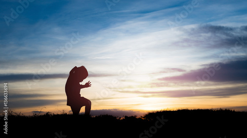 silhouette Kid walking on meadow on sunset