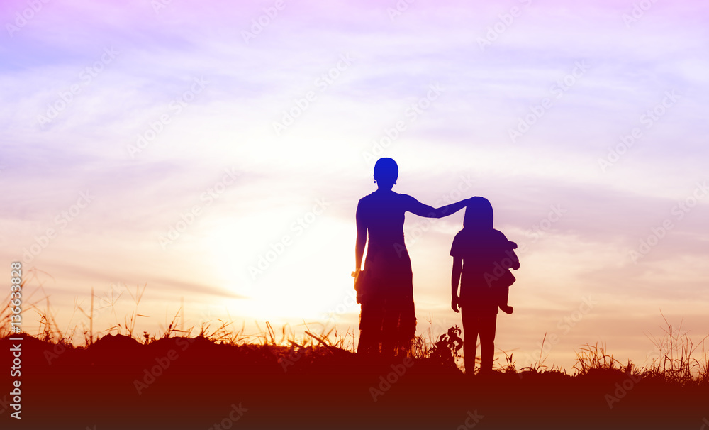 Silhouette of woman and her sister happy time at sunset