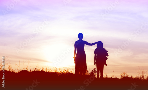 Silhouette of woman and her sister happy time at sunset