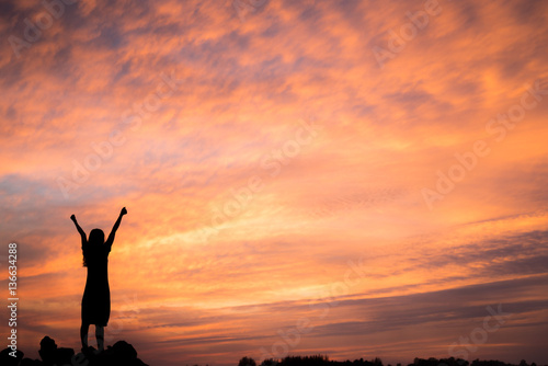 silhouette woman Happy celebrating winning success at sunset