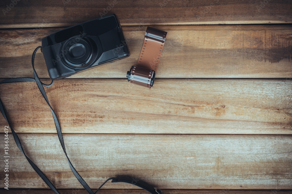 Old camera and 35mm film on wooden background Old camera and 35mm film on wooden background