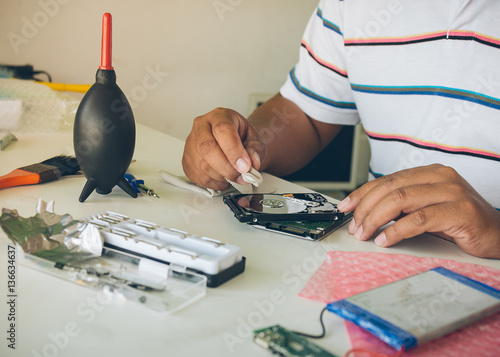 Hands of technician repair a hard disk