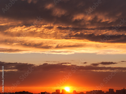 Dramatic sunset with bright Sun over skyline. Moscow, Russia. 