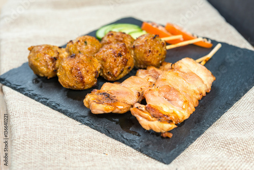 tasty grilled meat and vegetables skewers on a slate plate
