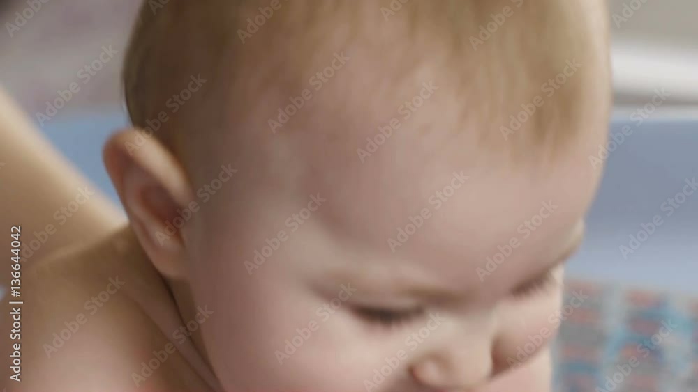 mother bathes smiling joyful child 9 months old mother bathes smiling joyful child 9 months old