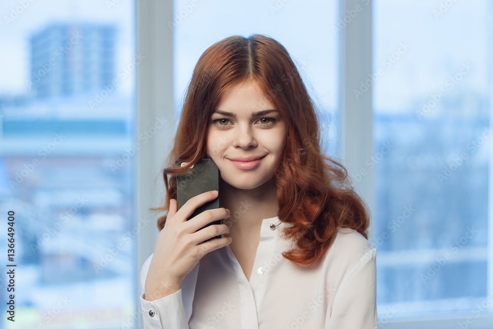 red-haired woman with phone in hand