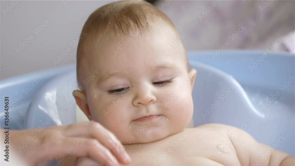 mother bathes smiling joyful child 9 months old mother bathes smiling joyful child 9 months old