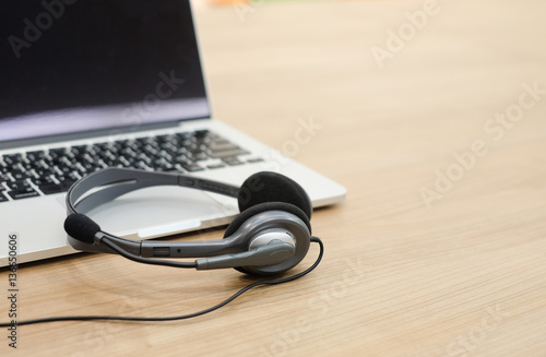 close up soft focus headphone call centre hotline at computer office table:operator helpline job:help-desk consult service support.blur business,technology concept:worldwide telecommunication company.