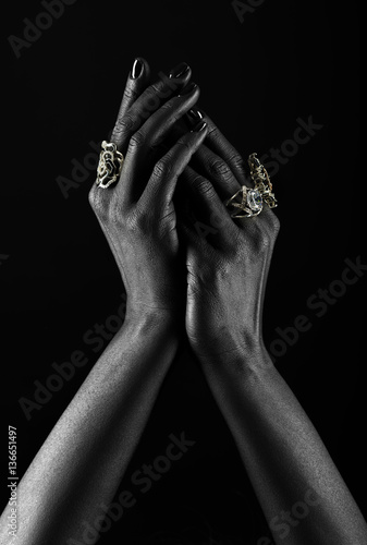 Dark-skinned hand with jewelry on a black background