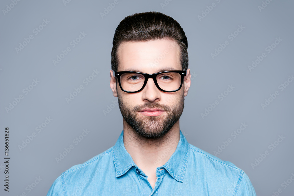 Portrait of handsome young bearded man in glasses on gray backgr Portrait of handsome young bearded man in glasses on gray backgr
