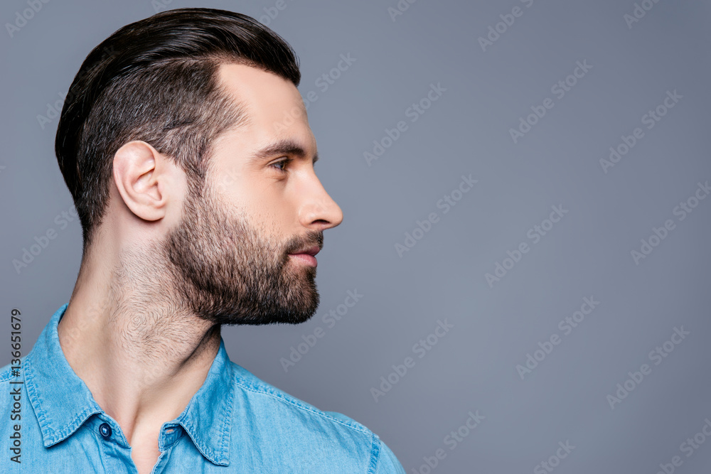 Naklejka premium Side view of young stylish man isolated on gray background
