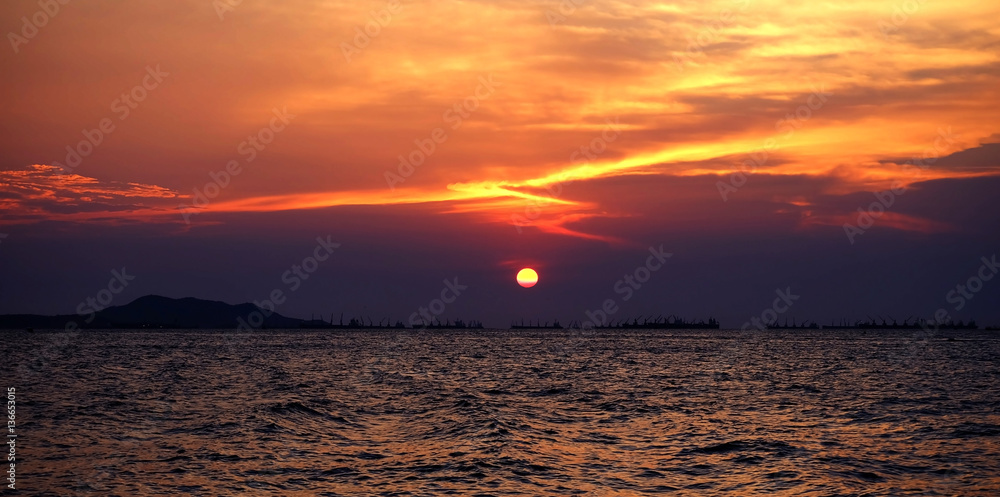 Obraz premium Sunset on the beach with fisherman boat and mountain.