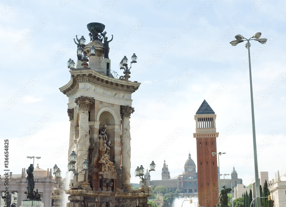 Marble sculpture monument and venetian tower in Plaza de Espana, on background National Art Museum, Barcelona