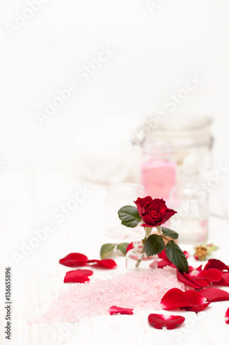 salt, rose water from rose petals with your hands on a white woo