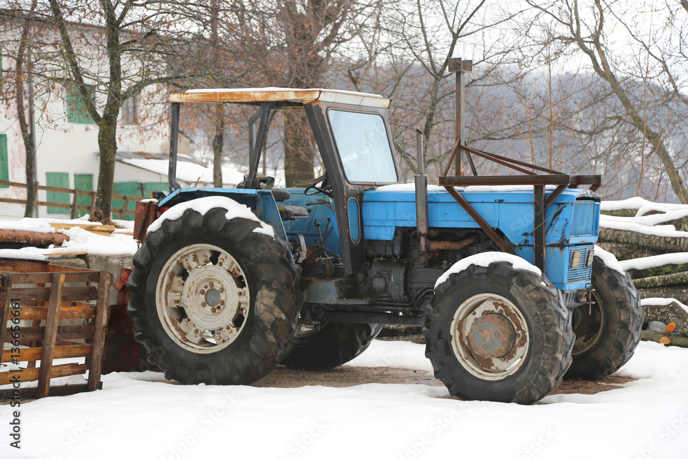 Fototapeta premium Blue old tractor on a farm in winter