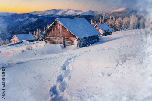 chalets in the mountains at sunset. Winter greetings