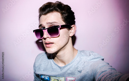 Attractive emotional  young man with glasses in studio