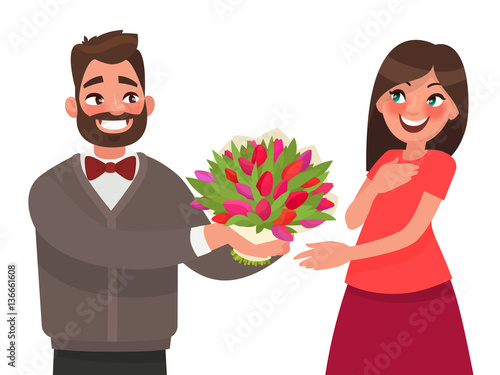 Man gives a woman a bouquet of flowers. Congratulations on a hol