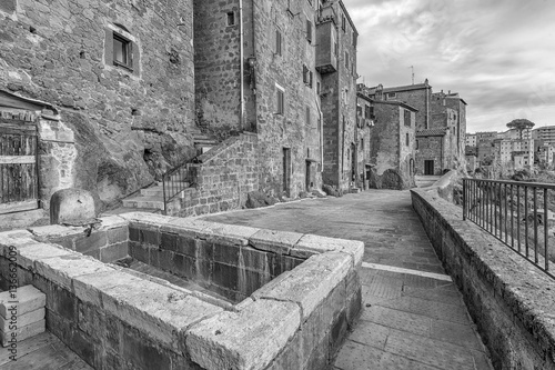 An ancient tub for washing clothes in the historic center of Pitigliano, Grosseto, Tuscany, Italy, in black and white