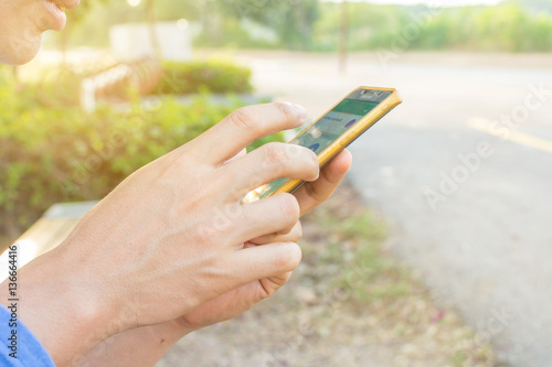 Man uses his Mobile Phone outdoor, close up