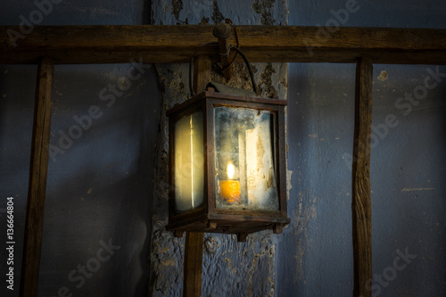 The old kerosene lamp on a wall in dark room