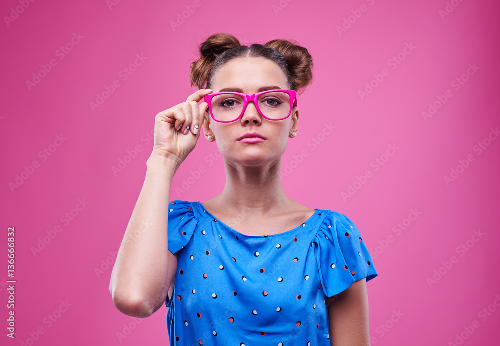 Young woman wearing pink glasses with a serious facial expressio Young woman wearing pink glasses with a serious facial expressio