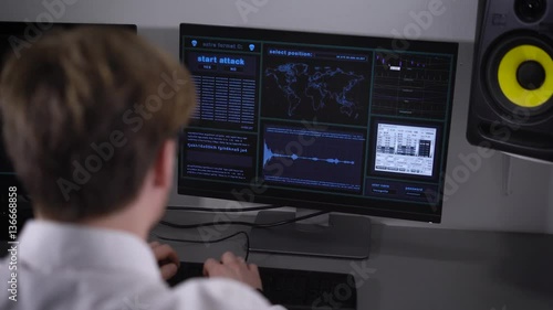 Computer room. The programmer by means of certain programs understands computer errors. The young man in a white shirt enters special codes and data into the computer.
