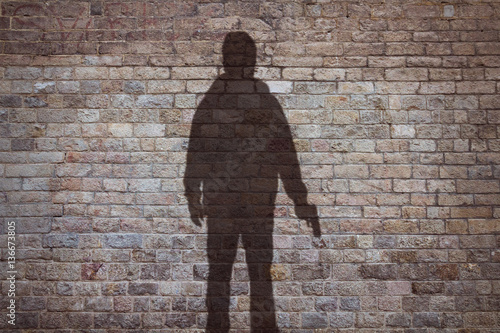 shadow of a man holding his gun