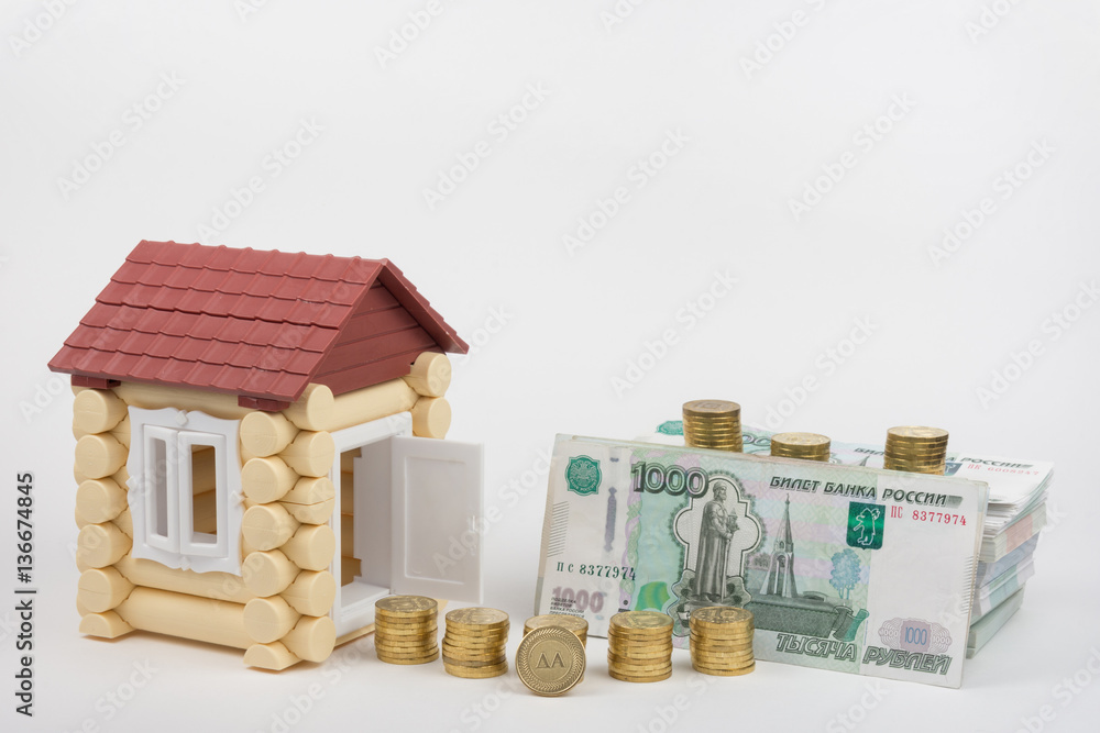 At toy house opened the door, the door are stacks of coins and bundles of bank notes, coins in the foreground with the word At toy house opened the door, the door are stacks of coins and bundles of bank notes, coins in the foreground with the word