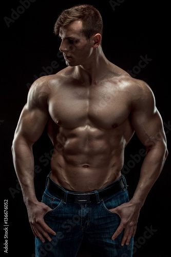 Young bodybuilder man on black background © nazarovsergey
