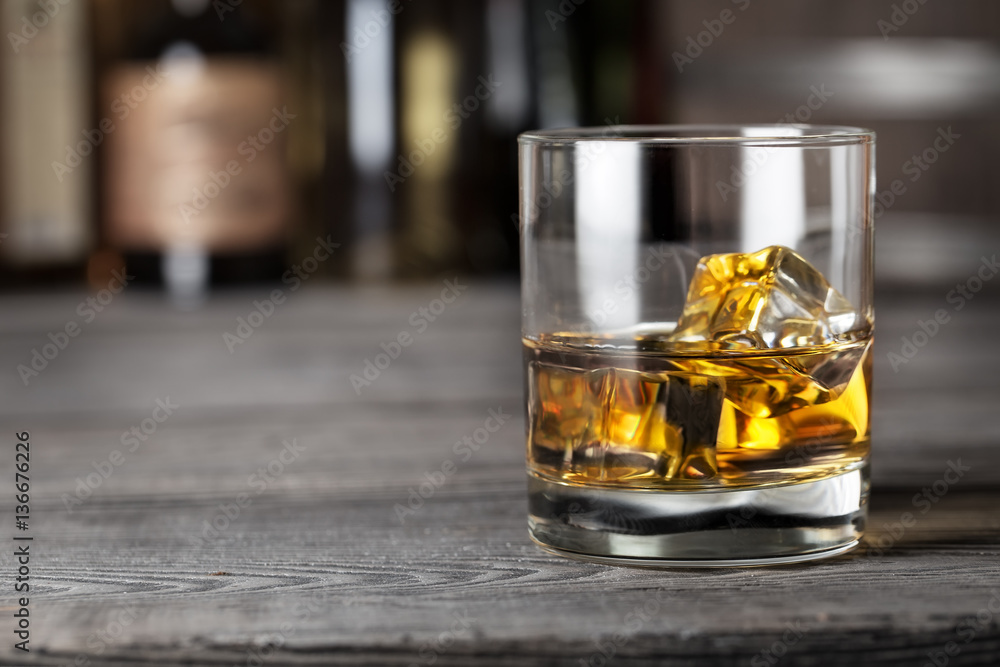 Glass of whiskey with ice on the bar rack Glass of whiskey with ice on the bar rack