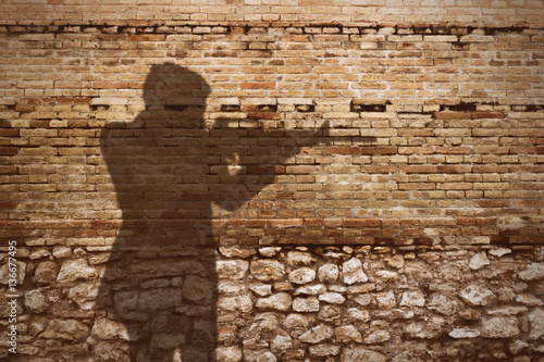 Canvas Print old brick wall with gunman shadow