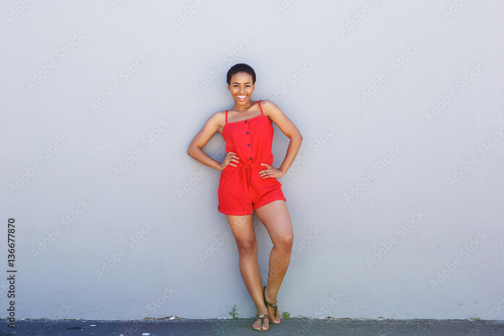 Naklejka premium Full body beautiful young woman smiling against gray wall