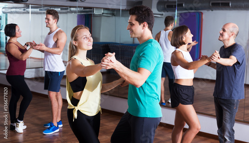 Dancing couples learning salsa