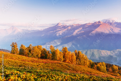 Autumn landscape and snow-capped mountain peaks. View of the mou photo