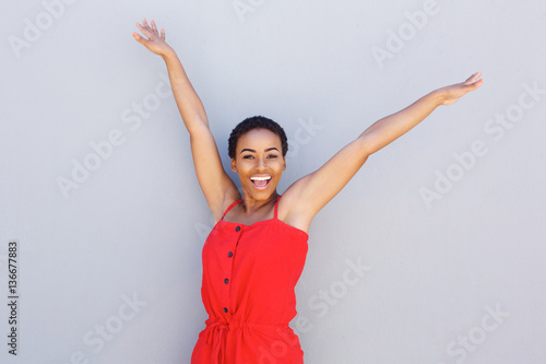 beautiful young black woman smiling with arms raised