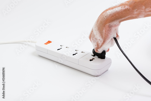 Wallpaper Mural Wet hand of children are plugged. Concept of do not use electricity with wet hand and safety of children. Torontodigital.ca