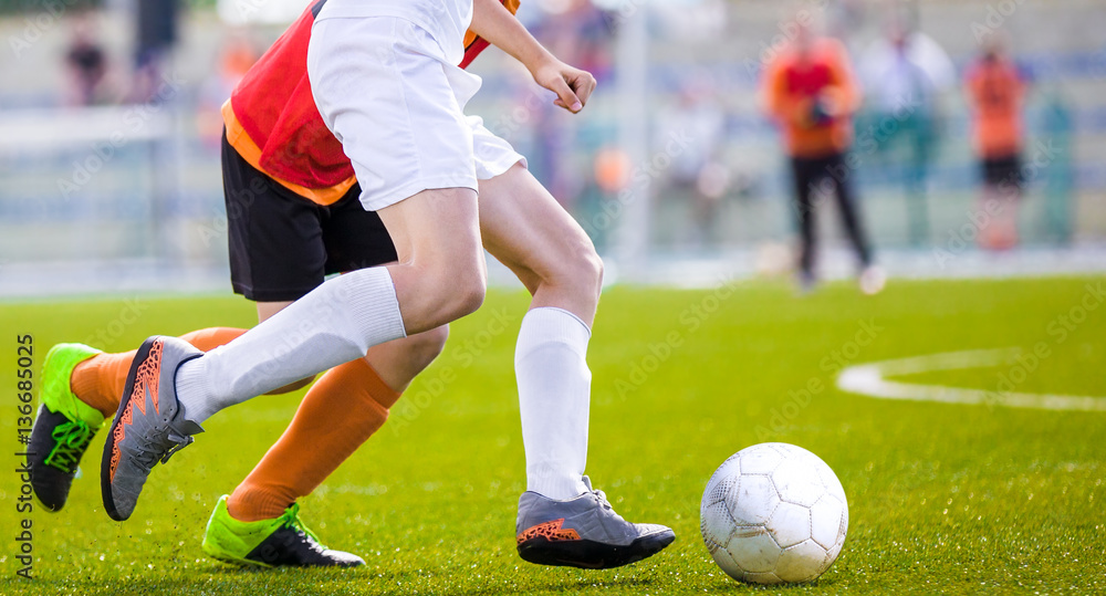 Fototapeta premium Soccer Players Running After the Ball on the Pitch. Football Match Between Two Teams. Outdoor Sports Competition