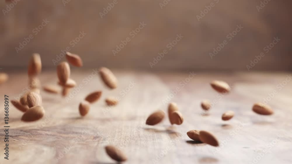 Slow motion of almonds falling on wooden table, 180fps prores footage Slow motion of almonds falling on wooden table, 180fps prores footage