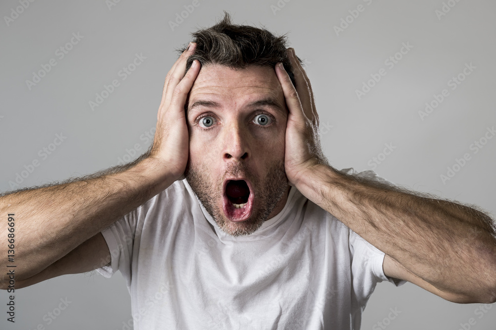 young attractive man astonished amazed in shock surprise face