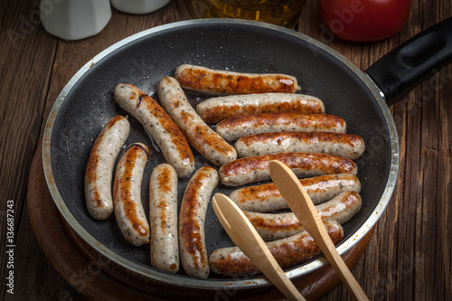 Fried white sausages in a cast iron skillet.