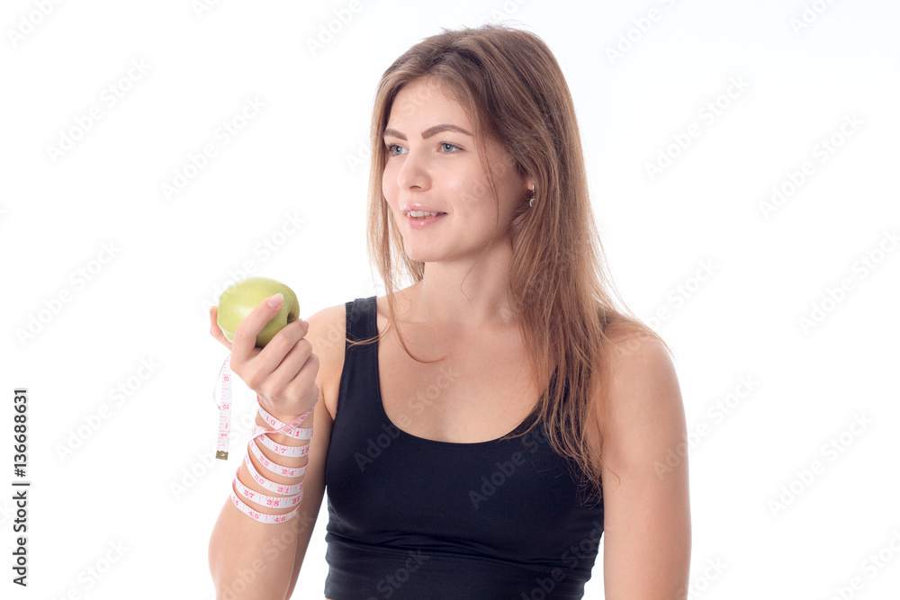 athletic girl standing sideways squeezing an apple in her hand athletic girl standing sideways squeezing an apple in her hand