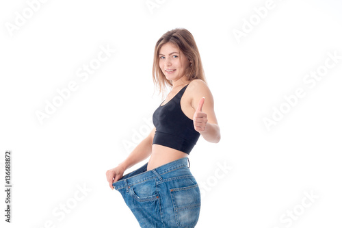 Slim young girl wore wide jeans isolated on white background