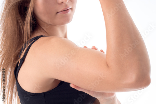 young girl shows off her biceps on arm close-up