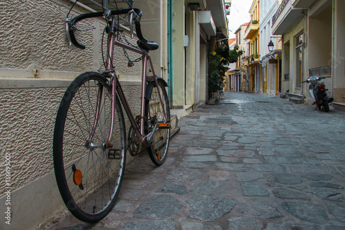 Parked vintage old bicycle from the street greek island town panorama