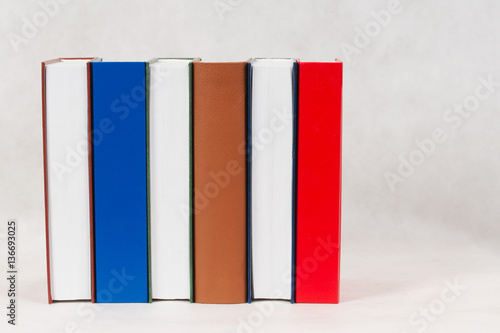 Stack of hardback books on wooden table. Back to school.